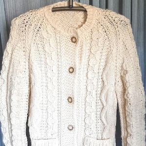 ivory colored hand crocheted button up wool cable stitch cardigan in excellent condition.  has two front pockets. S/M
